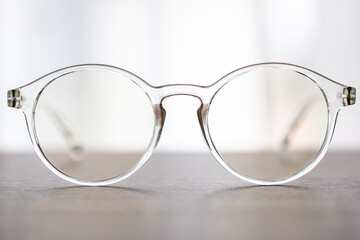 Fototapeta na wymiar Eyeglasses close up. Eye glasses. Modern style eyeglasses. Round glasses with transparent lenses.