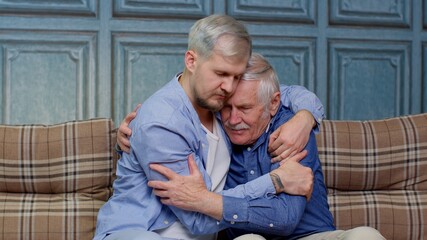 Adult man son hugging and consoling sadness old age father with love, mental health, social problems