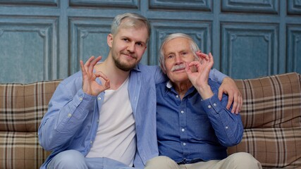 Different male generations family of senior father and adult son or grandson showing ok gesture sign