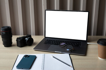 Laptop, film camera, Notepad with pen, phone on the wooden table office