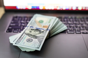 Dollars hundred banknotes on a laptop keyboard