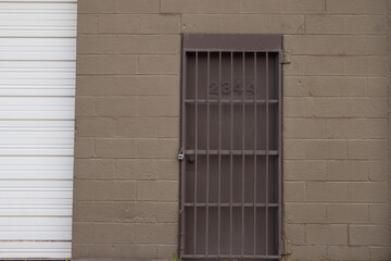 Brown wall with locked iron bars door