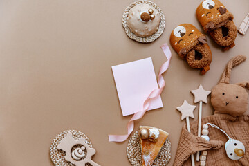 Top view Baby Shower accessories on brown background. Birthday cake, newborn items, pink card. ItÕs a girl background
