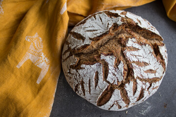 Fresh baked artisan bread on a table. Dark gray background with copy space. Homemade sourdough bread recipe. 