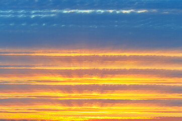 Colorful, unfocused cloudy sky background at sunset