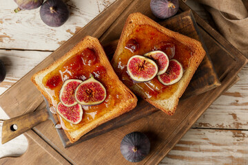 Tasty toasted bread with sweet fig jam on table
