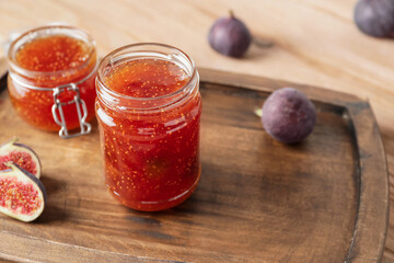 Jar of sweet fig jam on wooden table