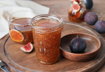 Jar of sweet fig jam on wooden table