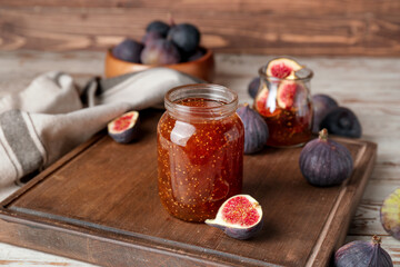 Jar of sweet fig jam on wooden table