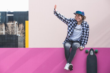 brunette woman with cap and skateboard on colorful background