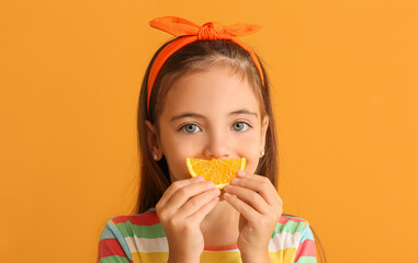 Funny little girl with orange on color background