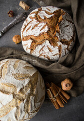 Golden crust loaf top view. Freshly baked sourdough bread on a table. Grey textured background. Artisan food and drink. 
