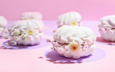 Tasty marshmallows with flowers on color background, closeup
