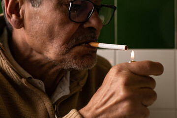 Older man lighting a cigarette with his lighter