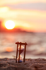 Stylish hourglass on sand outdoors