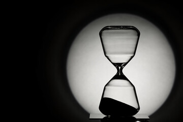 Silhouette of hourglass on dark background