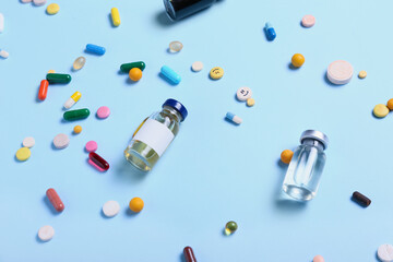 Different pills and ampules on color background