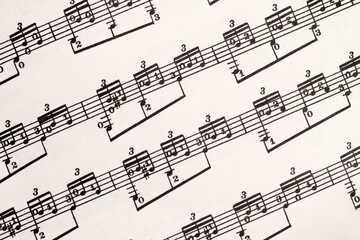 Music notes on sheet, guitar exercises fragment background