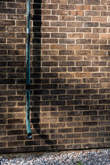 Red brick wall and greenish-blue gutter
