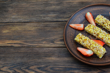 healthy food and fitness eating the concept of diet and breakfast, cereal bars with slices of strawberry berry on a clay plate