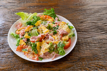 mixed salad plate with lettuce, tomato, cheese and ham.