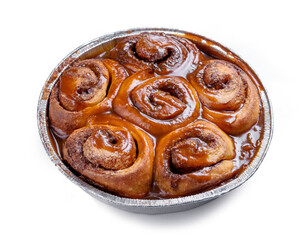 freshly baked cinnamon rolls covered with caramel sauce isolated on white background
