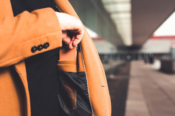 Man taking a wallet from the inside pocket of his coat