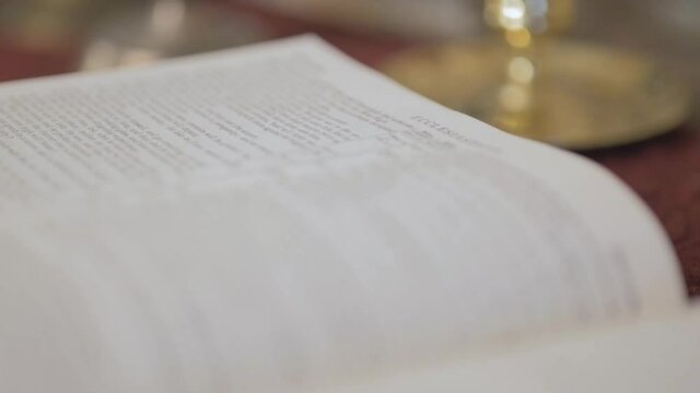 Close Up Of Open Bible With Slow Dolly Left. Low Angle