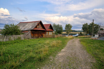 Fototapeta na wymiar Old wooden house with barn in the ancient village of Visim, Sverdlovsk region, Urals, Russia.
