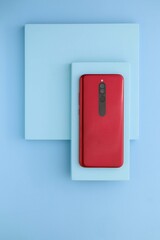 Red smartphone on the blue board, Blue table