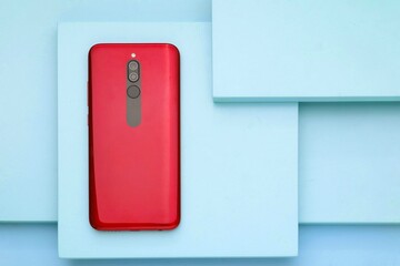 Red smartphone on the blue board, Blue table