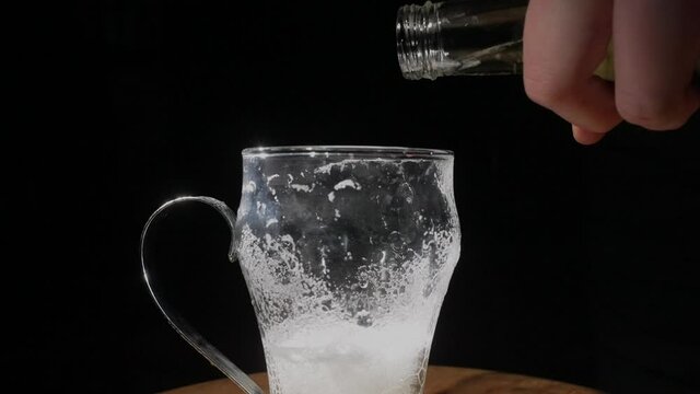 This slow motion video shows an anonymous hand pouring refreshing beer into a glass.