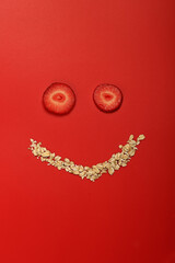 oatmeal with strawberries. Creative layout in the form of a face with a smile. Original design composition of healthy breakfast food