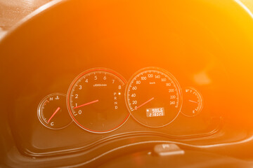 speedometer of a modern car with an integrated fuel gauge in the tank with white arrows under the yellow and orange neon color..
