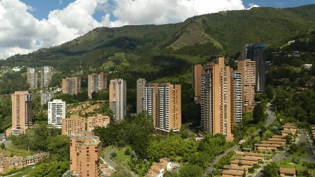Drone Descending in El Poblado Neighborhood of Medellin, Colombia with Clear View of Green Andes Mountains