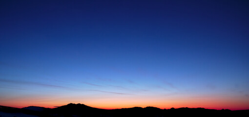山の稜線と美しいグラデーションの夜明けの空。