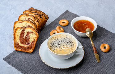 Breakfast with black coffee without milk on a blue-grey background with cupcake and jam