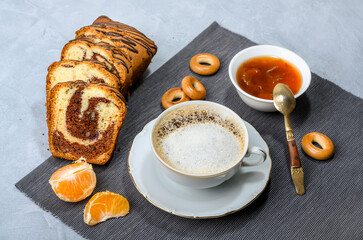 Breakfast with black coffee and cream on a blue-grey background with cupcake and jam