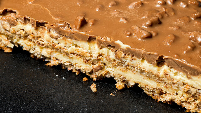 Slice of Swedish almond and chocolate cake with filling and nuts