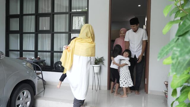 excited asian muslim family visiting friend during eid fitri mubarak at home