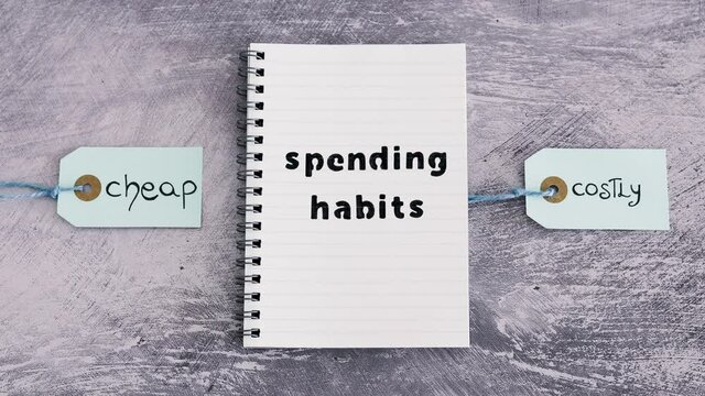 spending habits text on notepad with Cheap vs Costly prioduct price tags next to it, money and consumer behaviour