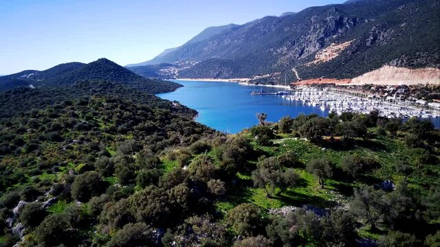 The top view from the drone of Kas resorts and city with amazing blue and clear lagoon and yachts in Mugla province of Turkey