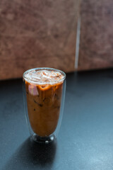 Close-up glass of iced coffee with milk on the table