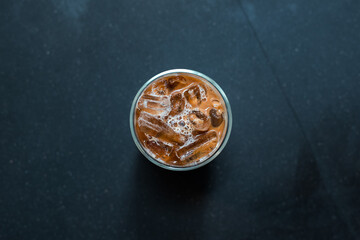 Close-up glass of iced coffee with milk on the table