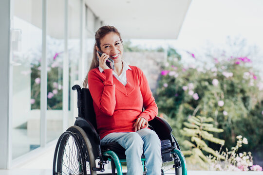 mexican woman talking by phone in wheelchair at workplace in Mexico city