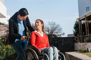 mexican latin woman in wheelchair and her friend having fun outdoors in Mexico