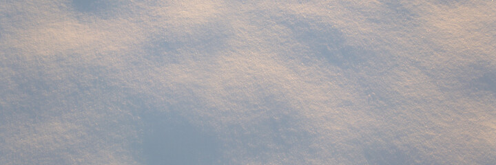 winter background: snowy field, lit by the setting sun, late evening