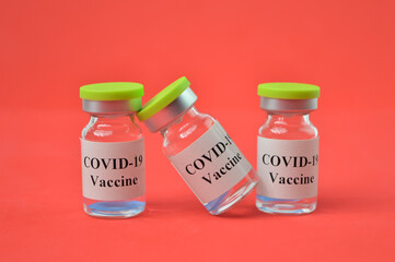 Covid-19 bottle vaccination over red background.