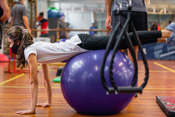young man with chinstrap mask in gym with ball
