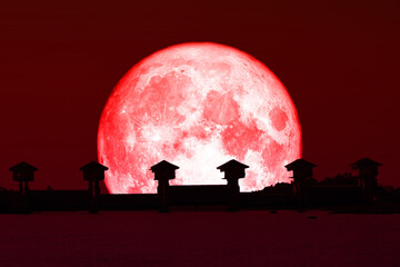 Super red moon and silhouette dam in the dark red sky